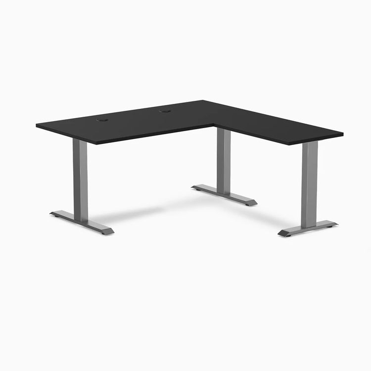 Black laminate L-shape office desk with space gray steel frame and grommets.