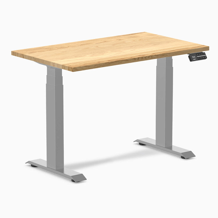 Desky Dual Mini 40x24 inch White Oak hardwood sit-stand desk with gray frame and control panel.