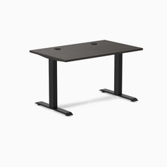 Desky Zero fixed-height office desk with burnished wood laminate top, grommets, and matte black steel frame.