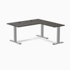 Burnished wood laminate L-shape office desk with gray steel frame and grommets.