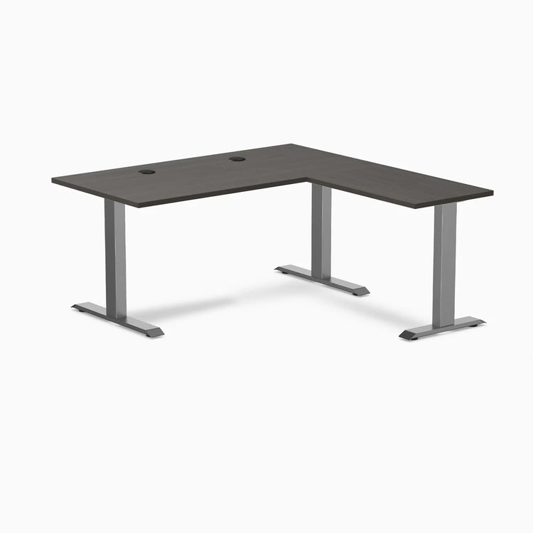Burnished wood laminate L-shape office desk with space gray steel frame and grommets.