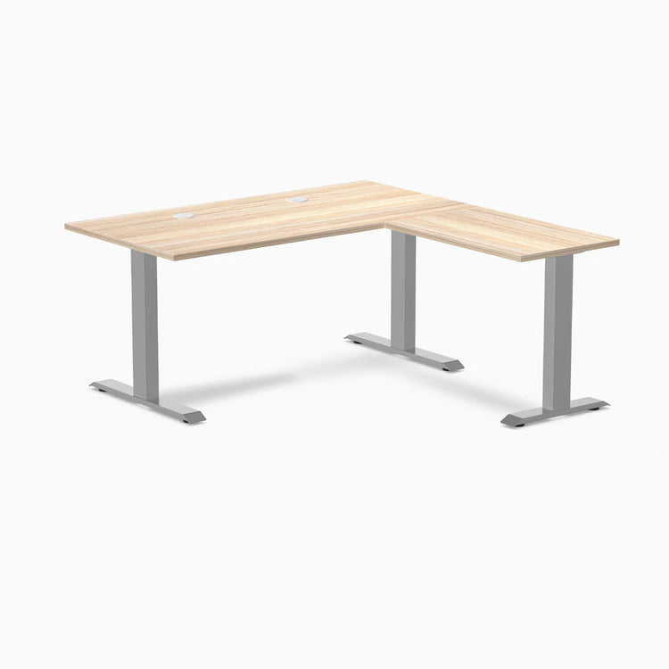 Classic Oak L-shape office desk with gray steel frame and grommets.
