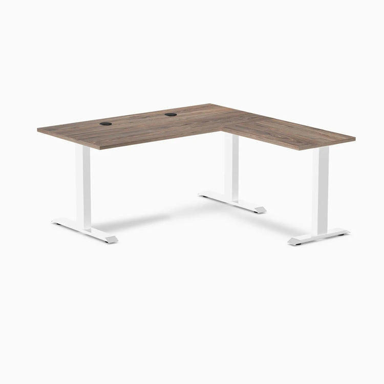 Desky Zero L-shape office desk in natural walnut laminate with white steel frame and grommets.