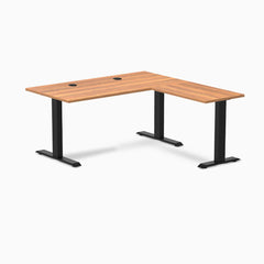 Prime Oak Desky Zero Laminate L-shape office desk with black steel frame and grommets.