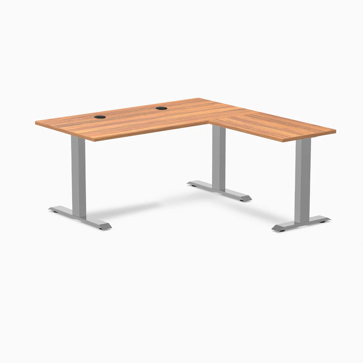 Prime Oak Desky Zero Laminate L-shape office desk with gray steel frame and grommets.