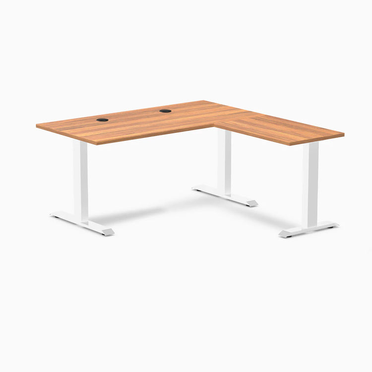 Desky Zero L-shape office desk with Prime Oak laminate top, white steel frame, and grommets.