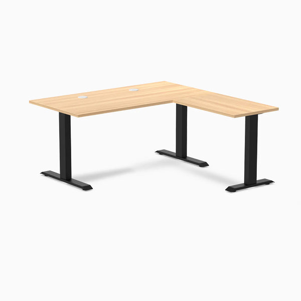 Desky Zero L-shape office desk with Sublime Teak laminate top, matte black steel frame, and grommets.