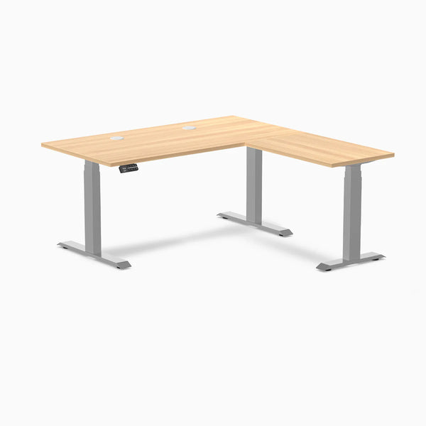 Desky L-Shape Laminate Sit Stand Desk in Sublime Teak with gray frame and grommets.