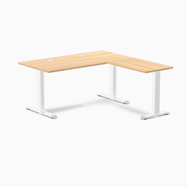 Desky Zero L-shape office desk with Sublime Teak laminate top, white steel frame, and grommets.