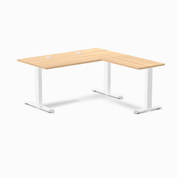 Desky Zero L-shape office desk with Sublime Teak laminate top, white steel frame, and grommets.