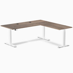 Desky L-Shape Laminate Sit Stand Desk in Natural Walnut with white frame and grommets.