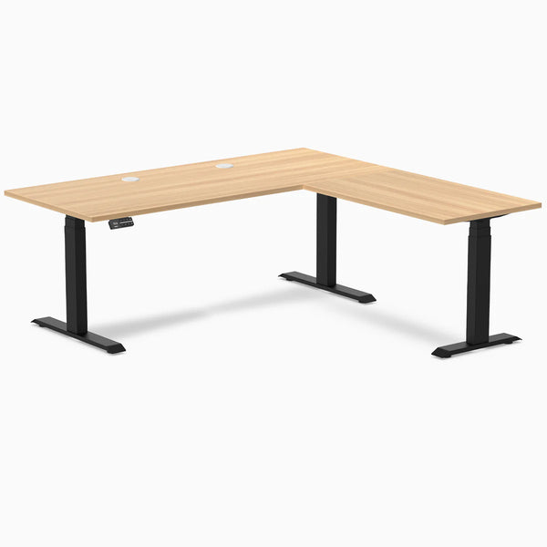 Desky L-Shape Laminate Sit Stand Desk in Sublime Teak with Matte Black frame and grommets.
