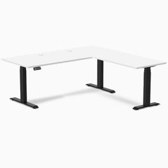White laminate L-shape sit-stand desk with matte black frame and grommets.