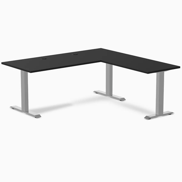 Black L-shape office desk with grommets, laminate top, and gray steel frame.