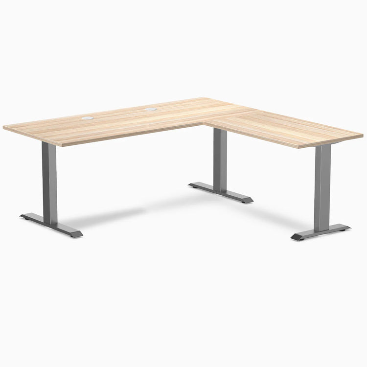 Classic Oak Desky Zero Laminate L-shape office desk with Space Gray steel frame and grommets.