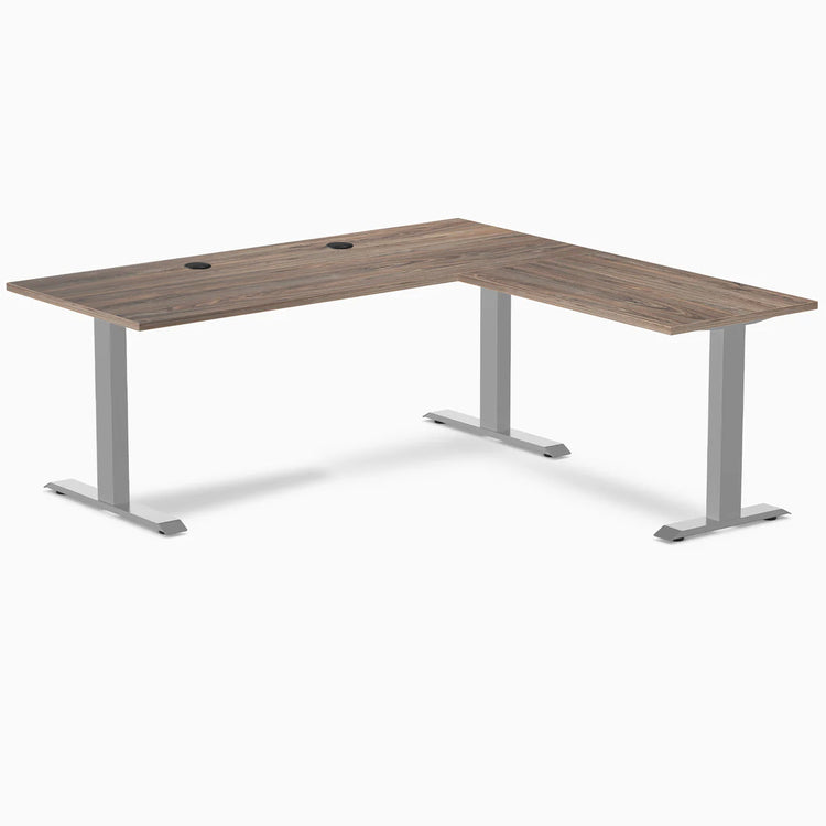 Natural walnut L-shape office desk with gray steel frame and grommets.