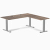Natural walnut L-shape office desk with gray steel frame and grommets.