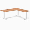 Prime Oak laminate L-shape office desk with white steel frame and grommets.