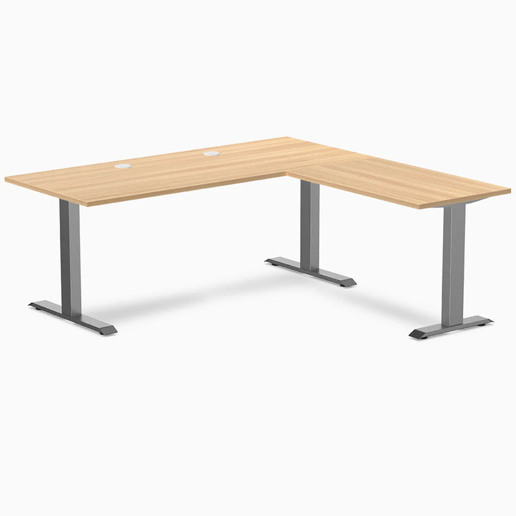 Desky Zero L-shape office desk in Sublime Teak laminate with Space Gray steel frame and grommets.