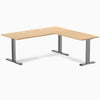 Desky Zero L-shape office desk in Sublime Teak laminate with Space Gray steel frame and grommets.