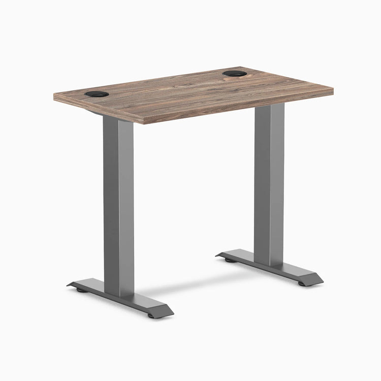 Desky Zero Mini fixed-height desk with natural walnut top, space gray legs, and grommets.