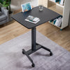 Desky Single Sit Stand Pedestal Desk in living room with gadgets on top