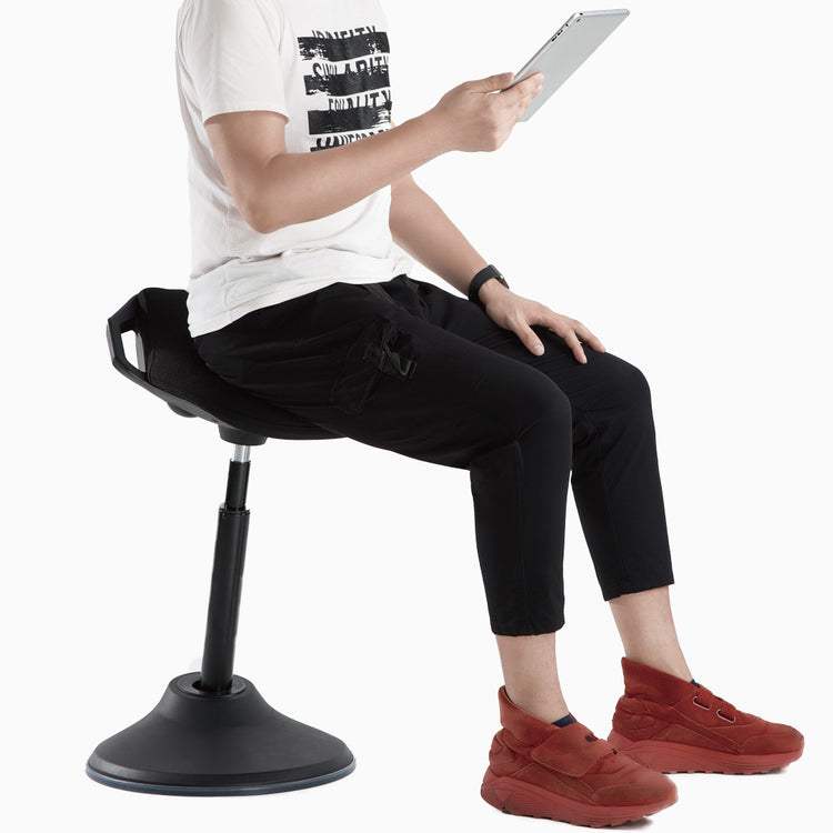 Guy sitting on sit stand pro active stool while using tablet