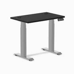 Black Desky Dual Mini sit-stand desk, 32x20 inch top with grommets, gray frame.
