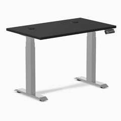 Black Desky Dual Mini sit-stand desk, 40x24 inch top with grommets, gray frame, and digital controller.
