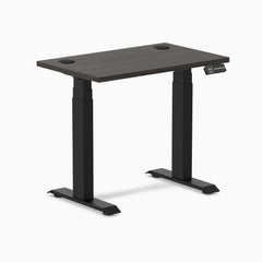 Compact Desky Dual Mini sit-stand desk with burnished wood top, matte black frame, and grommets.