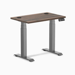 Desky Dual Mini sit-stand desk with Jarrah Legno top, Space Gray legs, and grommets.