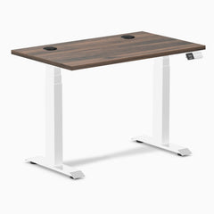Desky Dual Mini sit-stand desk with Jarrah Legno top, white frame, and two grommets.