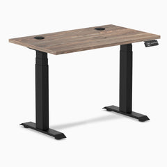 Desky Dual Mini sit-stand desk with natural walnut top, 40x24 inches, grommets, and matte black frame.