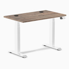 Desky Dual Mini Sit Stand Desk with natural walnut top, white frame, and two grommets.