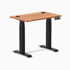 Desky Dual Mini sit-stand desk with Prime Oak top, 32x20 inches, black frame, and grommets.