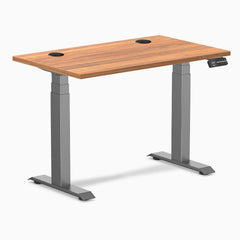 Desky Dual Mini sit-stand desk with Prime Oak 40x24 inch top, Space Gray frame, and grommets.