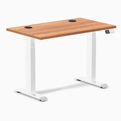 Desky Dual Mini sit-stand desk with a Prime Oak 40x24 inch top, white frame, and grommets.