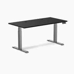 Desky Dual sit-stand desk with black laminate top, space gray frame, and two grommets.