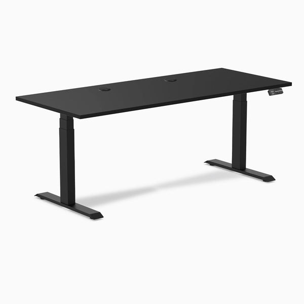 Desky Dual black laminate sit-stand desk, 70.9x29.5 inches, with grommets and matte black frame.