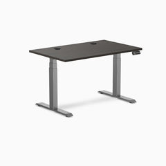 Desky Dual Laminate Sit Stand Desk with burnished wood top, two grommets, and space gray frame.