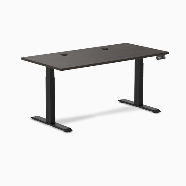 Desky Dual sit-stand desk with burnished wood laminate top, 59.1x29.5 inches, grommets, and matte black frame.