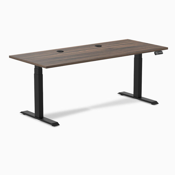 Desky Dual sit-stand desk with Jarrah Legno laminate top, 70.9x29.5 inches, grommets, and matte black legs.
