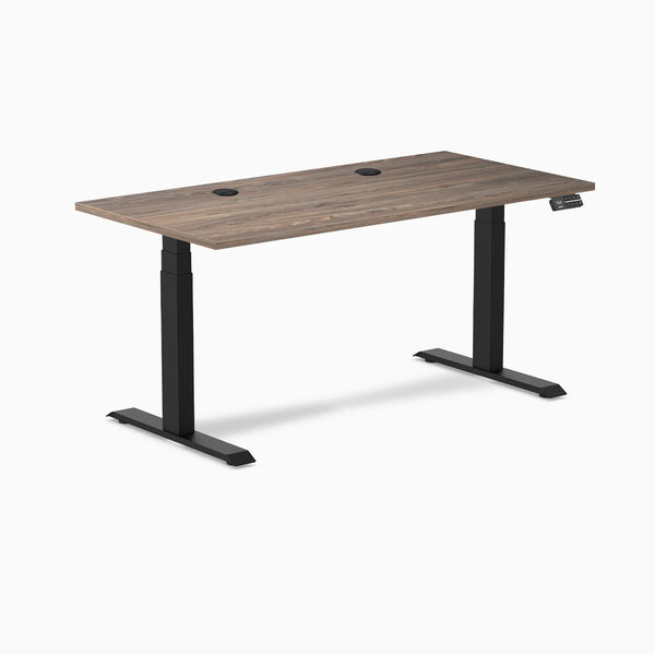 Desky Dual Sit Stand Desk with Natural Walnut laminate top, two grommets, and matte black frame.