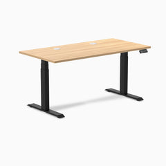 Desky Dual sit-stand desk with Sublime Teak laminate top, two grommets, and matte black frame.