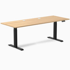 Desky Dual sit-stand desk with Sublime Teak laminate top, black frame, and two grommets.