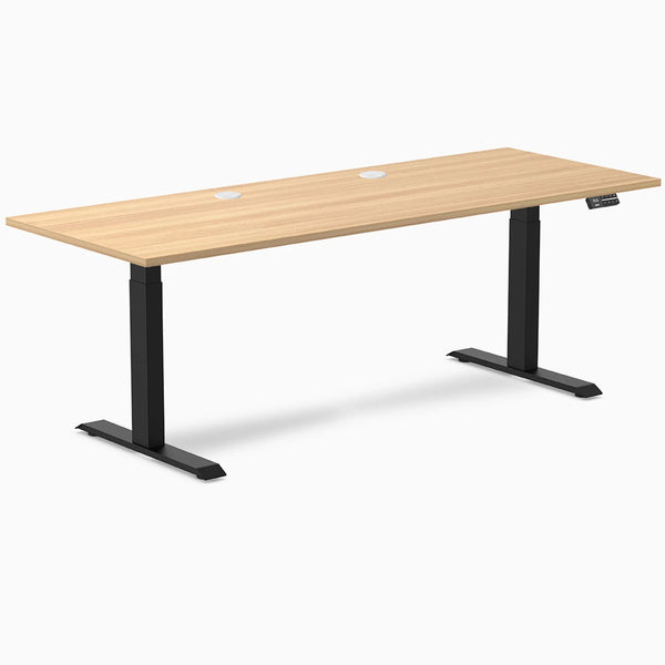 Desky Dual sit-stand desk with Sublime Teak laminate top, black frame, and two grommets.