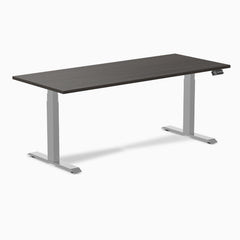 Desky Dual Laminate Sit Stand Desk with dark wood top and silver adjustable legs, featuring a control panel.