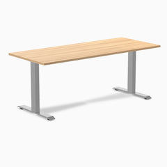 Desky Zero fixed height office desk with light wood laminate top and silver steel frame.